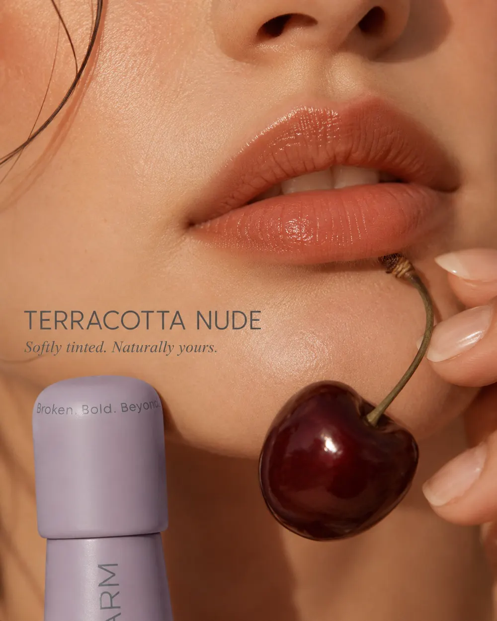 Close-up of lips wearing the Terracotta Nude shade, a cherry and MatteLip bottle in frame